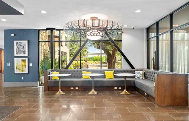 A modern living room with a grey sofa and a large window.