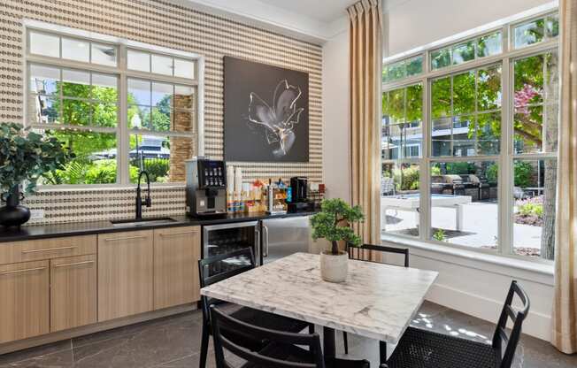 a kitchen with a table and chairs in front of a window