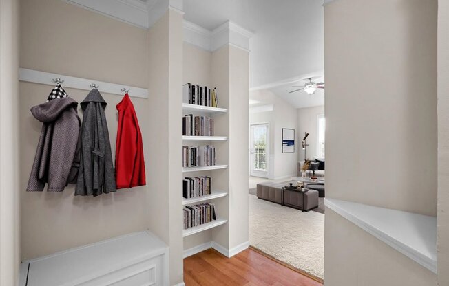 a hallway with a closet with clothes hanging on the wall and a staircase