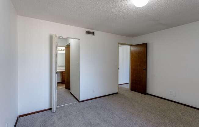 a bedroom with white walls and carpet