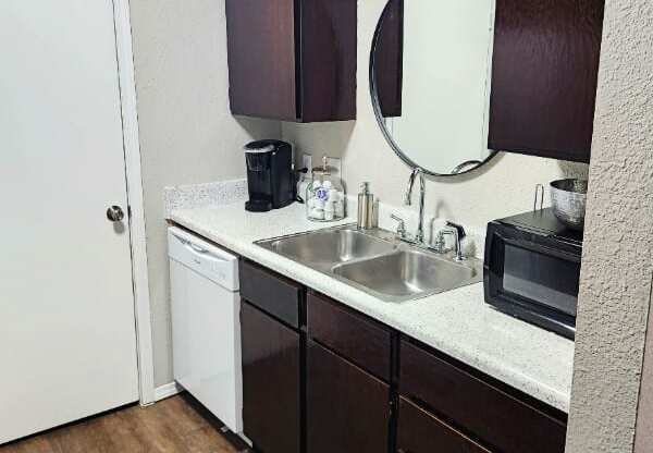 A small kitchen with a white door and a white sink.
