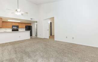 A room with a carpeted floor and a ceiling fan.