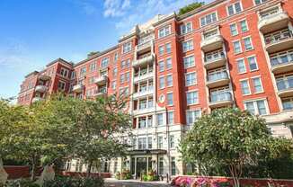 a large red brick apartment building with trees in front of it