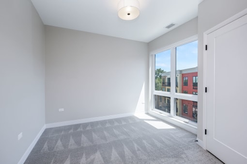 a living room with a large window and a carpet