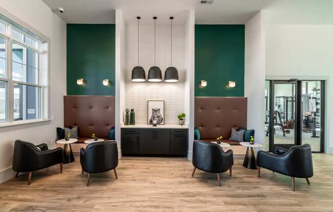 a living room with chairs and tables and a kitchen in the back