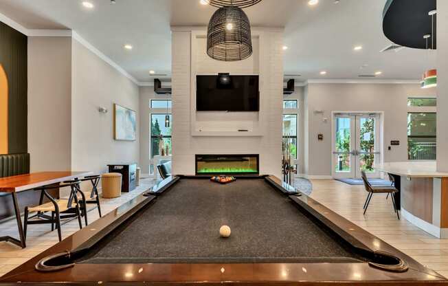 a billiards room with a pool table and a television