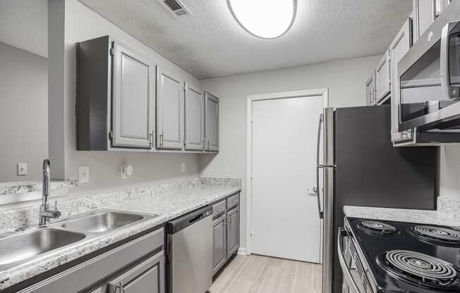 an empty kitchen with stainless steel appliances and granite counter tops