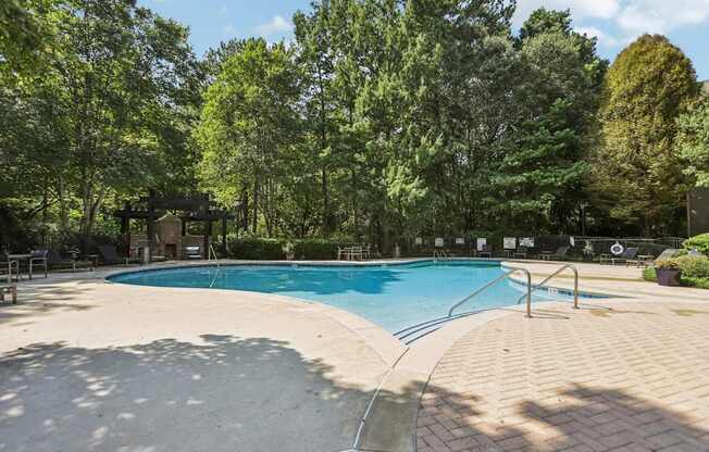 A large outdoor swimming pool surrounded by trees.