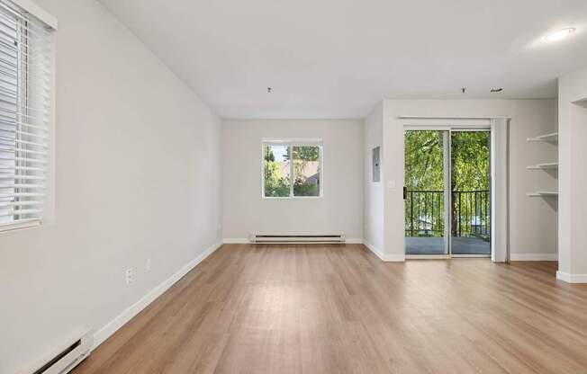 A room with wooden floors and a window with blinds.
