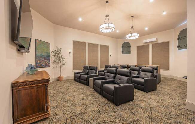 A room with a carpeted floor and a row of black leather chairs.