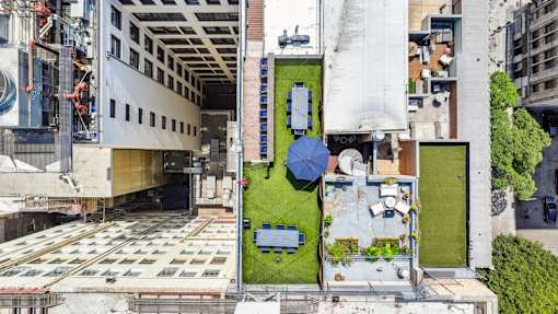 A building with a grass area and a blue umbrella.