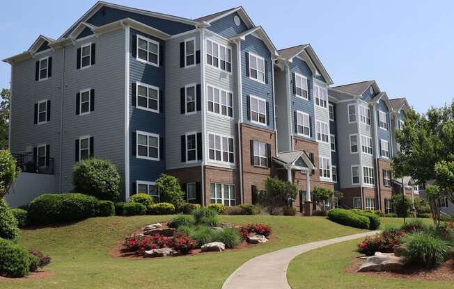 an exterior view of an apartment building with a sidewalk