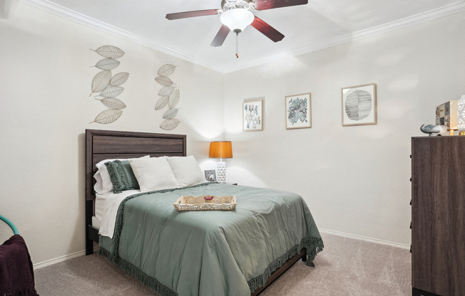 a bedroom with a bed and a ceiling fan at La Ventura Apartments, Texas, 75093