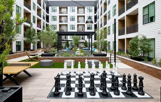 A giant chess board is in the middle of a courtyard.