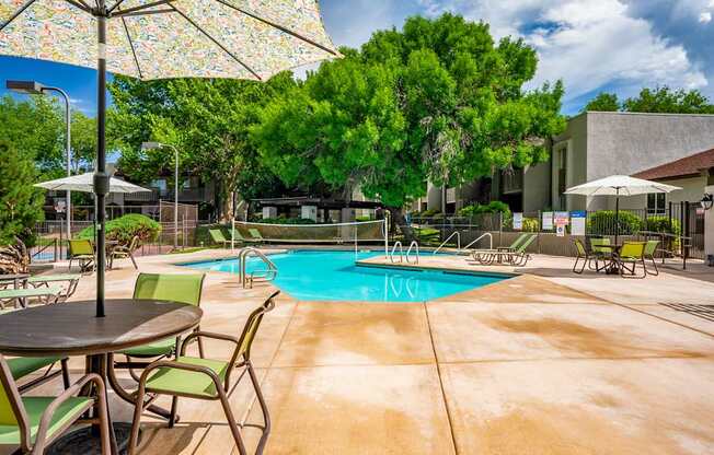 A pool area with chairs and umbrellas.