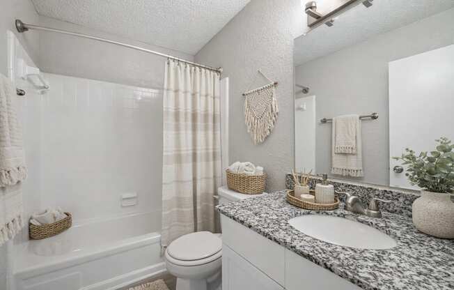 A bathroom with a toilet, sink, and shower.