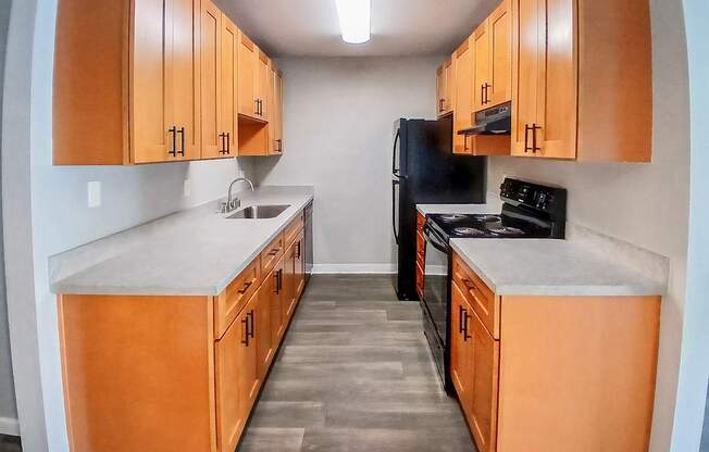A kitchen with wooden cabinets and black appliances.