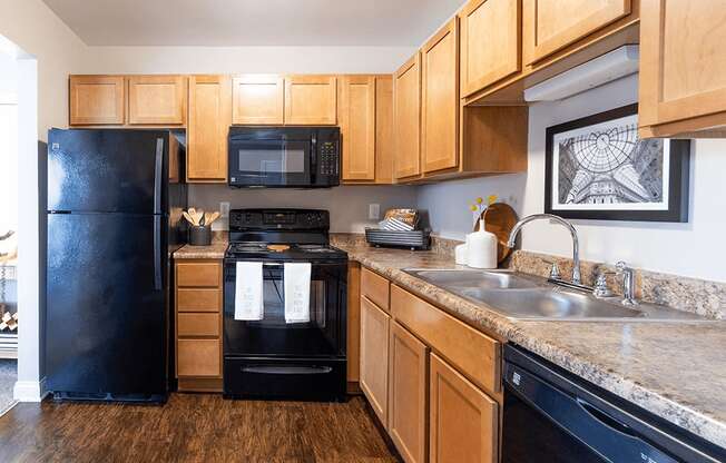 a kitchen with black appliances and wooden cabinets