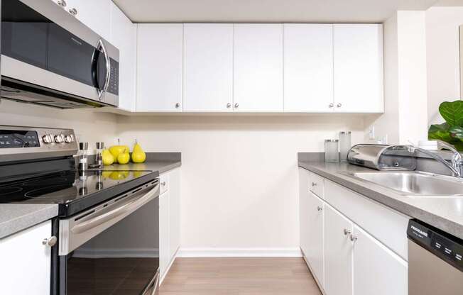 A kitchen with white cabinets and a stainless steel oven.