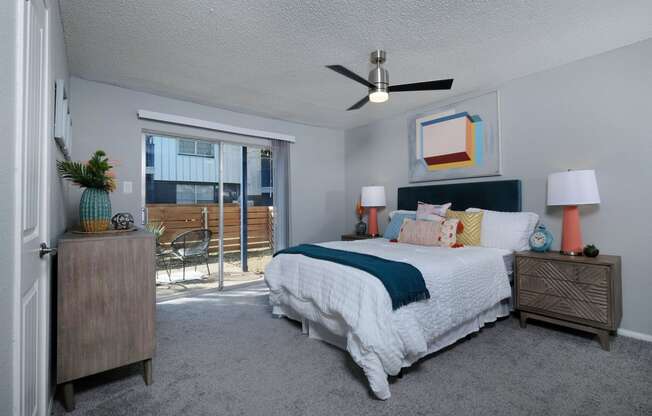 Apartments Arlington - Stadium 700 - Spacious Bedroom with Carpeting, Grey Walls, Popcorn Ceiling, Ceiling Fan, and Access to Outdoor Patio