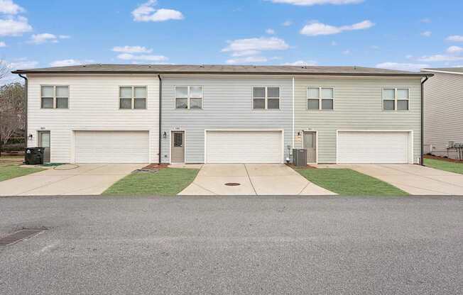 A row of houses with garages and driveways.