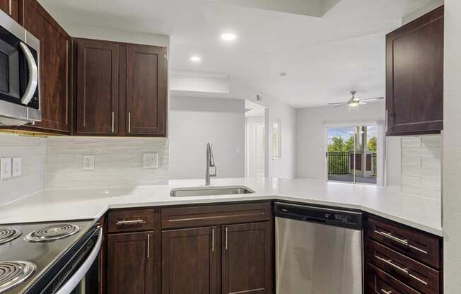 a kitchen with white countertops and wooden cabinets