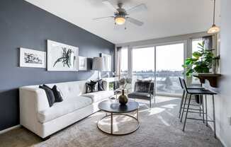 a living room with a large window and a ceiling fan