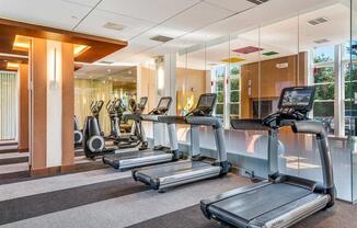 a gym with cardio equipment in the lobby of a building