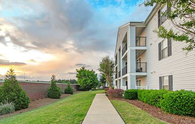 exterior view of apartments with sidewalk and grass at Avalon Apartment Homes, Starkville, 39759