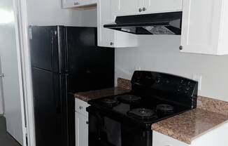 a kitchen with white cabinets and black appliances