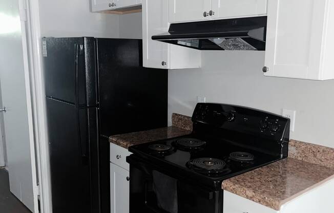 a kitchen with white cabinets and black appliances