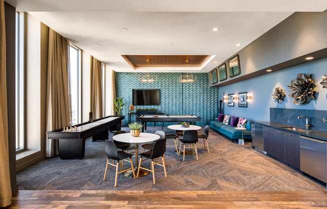 A modern living room with a pool table and a kitchen area.