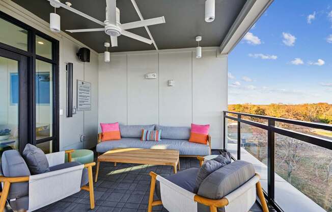 a living room with couches and chairs on a balcony at Link Apartments® Calyx, Chapel Hill North Carolina