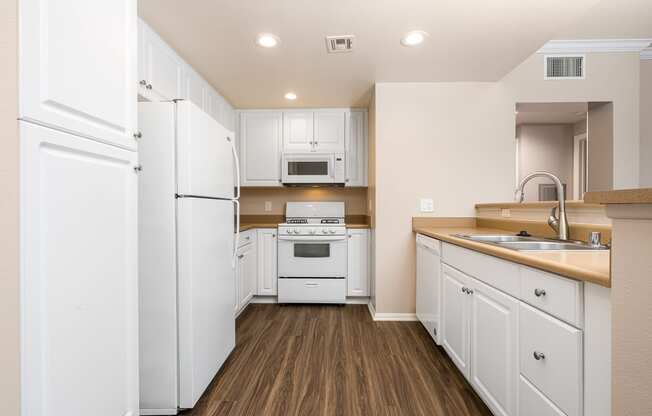 a kitchen with white cabinets and white appliances