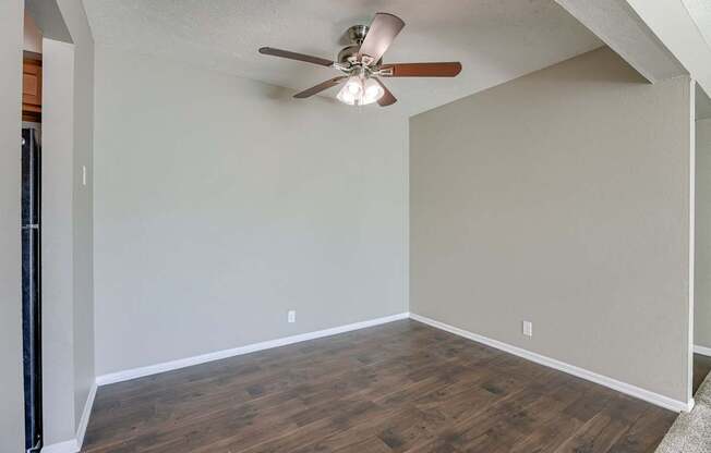 A room with a ceiling fan and wooden flooring. Omaha, NE Evergreen Terrace Apartments