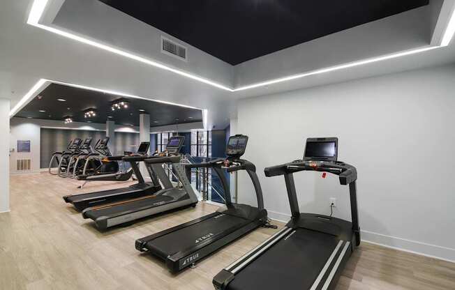 A gym with treadmills and elliptical machines.