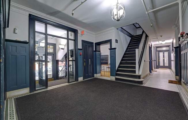 the lobby of a building with blue doors and a staircase