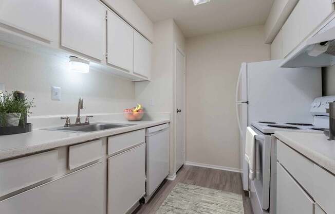 A kitchen with white cabinets and a sink.