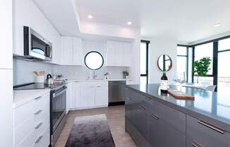 a kitchen with white cabinets and stainless steel appliances