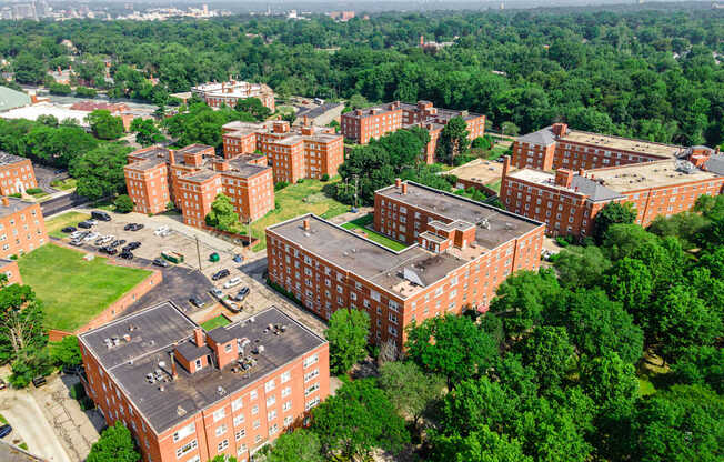 A large red brick building surrounded by trees.