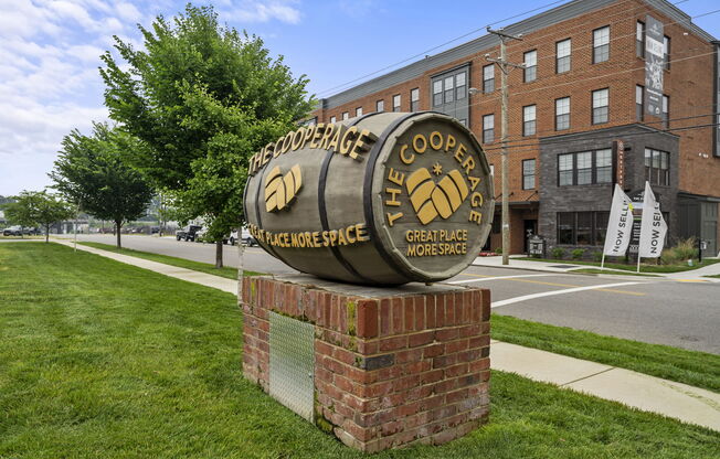 a large metal barrel sign in front of a brick building