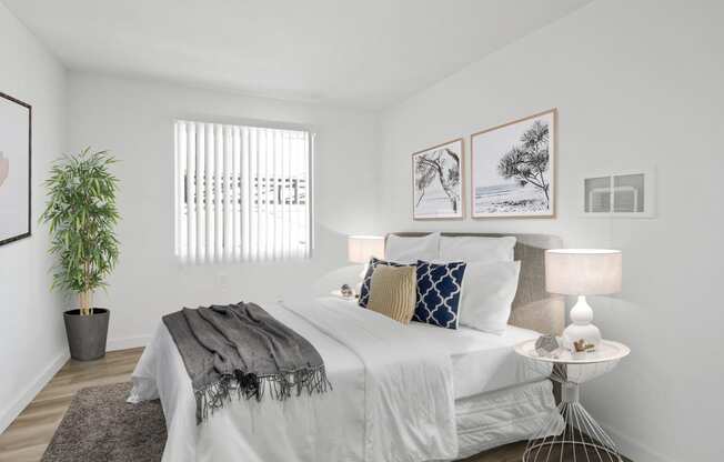 a bedroom with white walls and white bedding