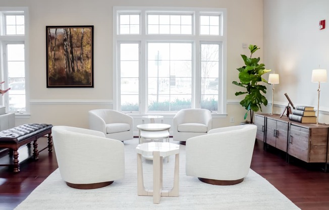 a living room with white furniture and a large window
