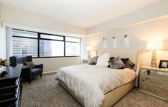 a bedroom with a large bed and a large window at Apartments at Denver Place, Denver, CO 80202