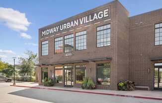 A building with the sign "Midway Urban Village" on top.
