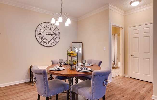 a dining room with a table and chairs and a clock on the wall