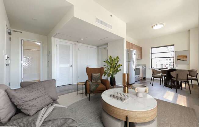 A modern living room with a grey couch and a round coffee table.