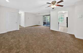 A room with a ceiling fan and carpeted floor.