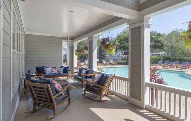 a covered porch with rocking chairs and couches
