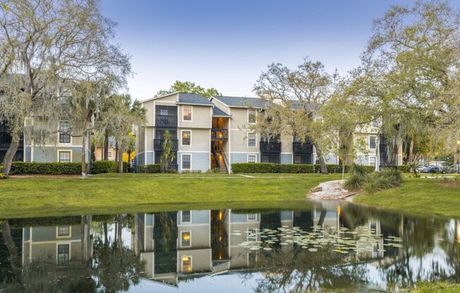 A house with a pond in front of it.